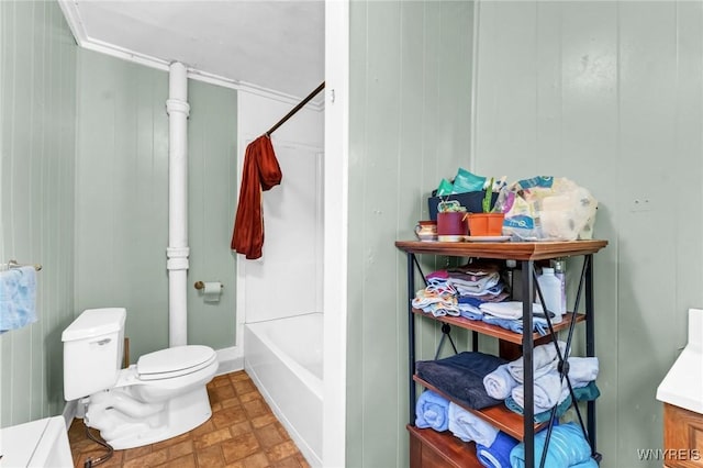 bathroom featuring shower / bathtub combination, toilet, and wooden walls