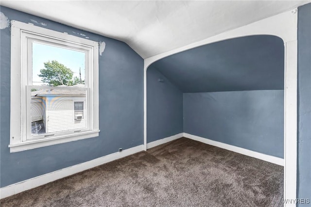 bonus room featuring dark carpet and vaulted ceiling