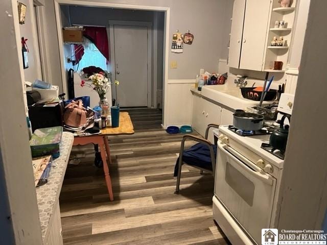 kitchen featuring white gas range, white cabinetry, and light wood-type flooring