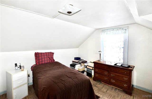 bedroom featuring vaulted ceiling and parquet flooring