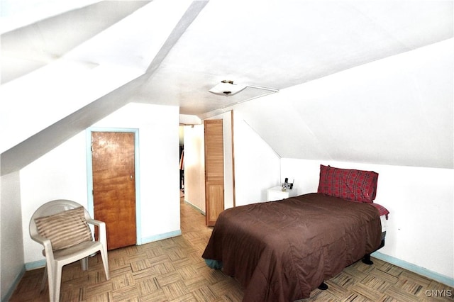 bedroom with light parquet flooring and vaulted ceiling