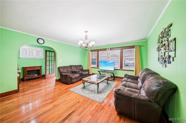 living room featuring a chandelier, light hardwood / wood-style flooring, and crown molding