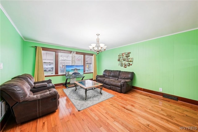 living room featuring light wood-type flooring, crown molding, and a chandelier