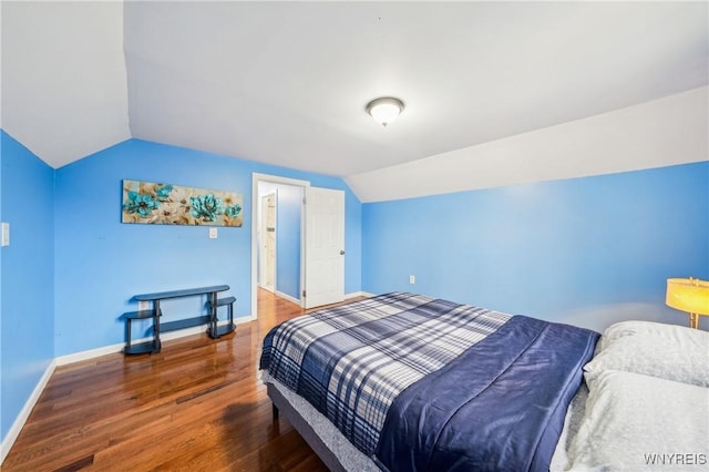 bedroom with dark hardwood / wood-style floors and vaulted ceiling