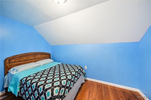 bedroom featuring hardwood / wood-style flooring and vaulted ceiling