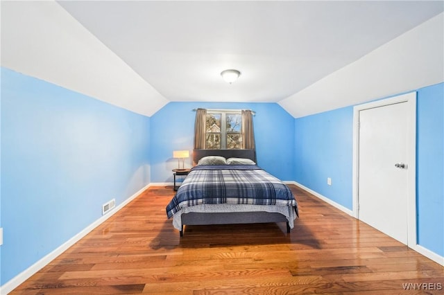 bedroom featuring vaulted ceiling and light hardwood / wood-style flooring