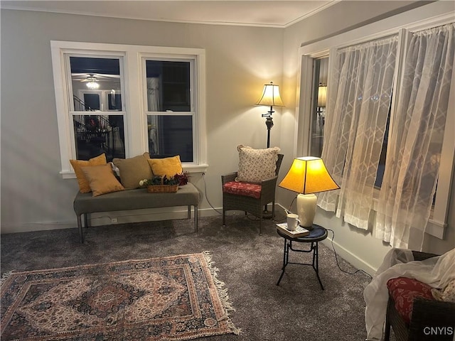 living area featuring dark carpet and ornamental molding