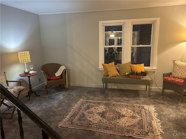 living area featuring dark carpet and ornamental molding