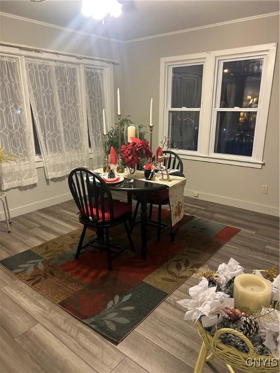 dining space with hardwood / wood-style flooring and ornamental molding