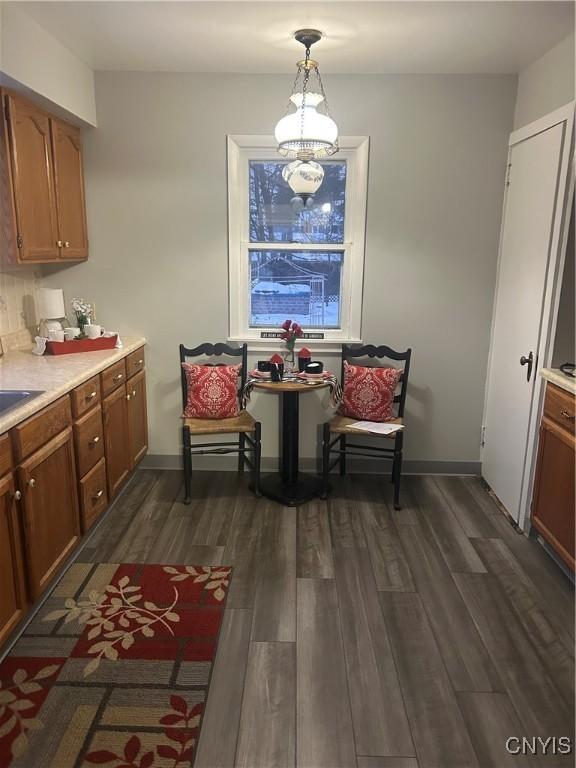 dining area with dark hardwood / wood-style floors, sink, and an inviting chandelier