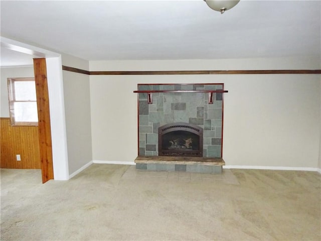 unfurnished living room featuring carpet, wood walls, and a fireplace