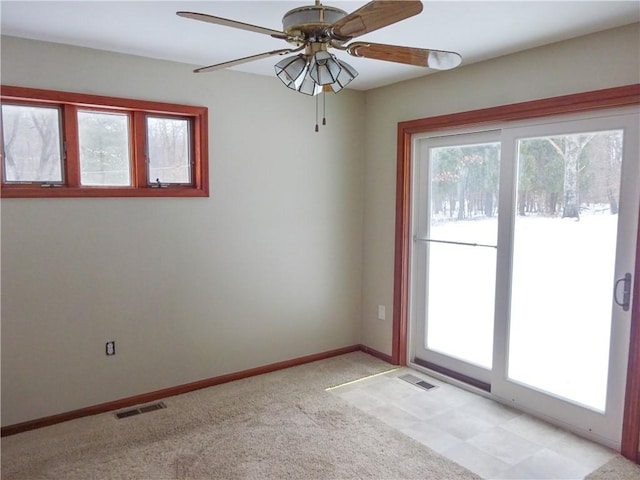 spare room with light carpet, plenty of natural light, and ceiling fan