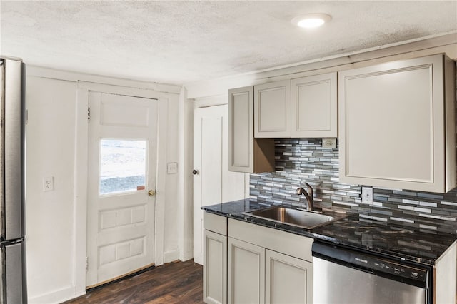 kitchen featuring sink, appliances with stainless steel finishes, dark hardwood / wood-style floors, tasteful backsplash, and a textured ceiling