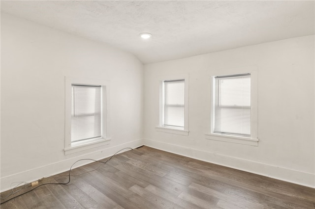 empty room with lofted ceiling and hardwood / wood-style floors