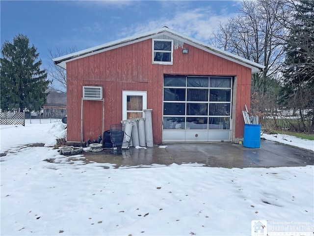 snow covered garage featuring an AC wall unit