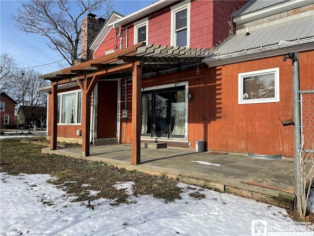 snow covered property with a patio