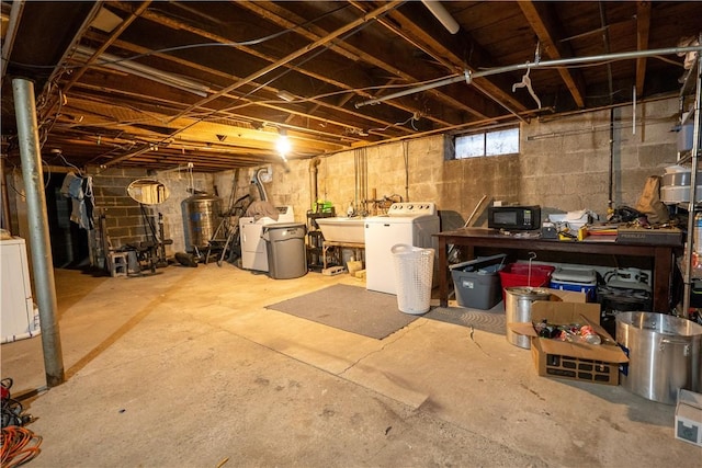 basement featuring washer and clothes dryer and sink