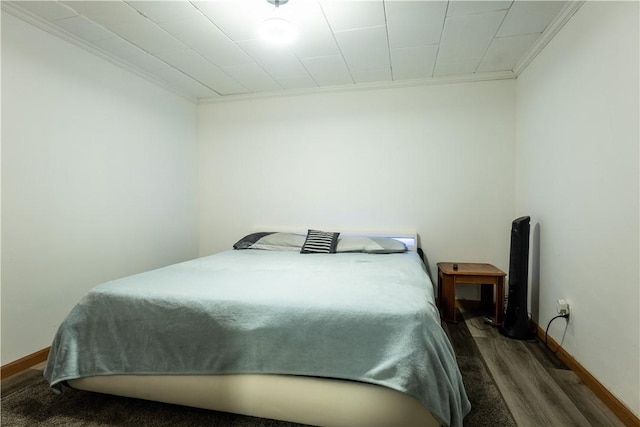 bedroom featuring ornamental molding and dark wood-type flooring