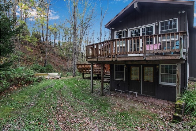 back of property with stairs, board and batten siding, and a wooden deck