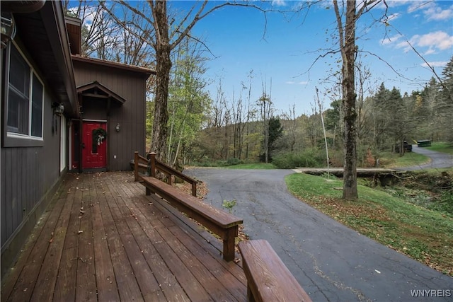 wooden terrace featuring a wooded view