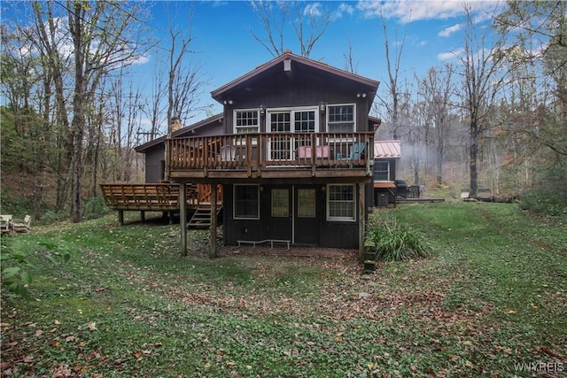 back of property with a deck, stairway, a yard, and a chimney