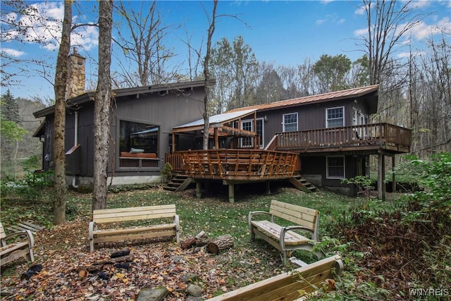 back of house featuring a deck, stairway, and metal roof