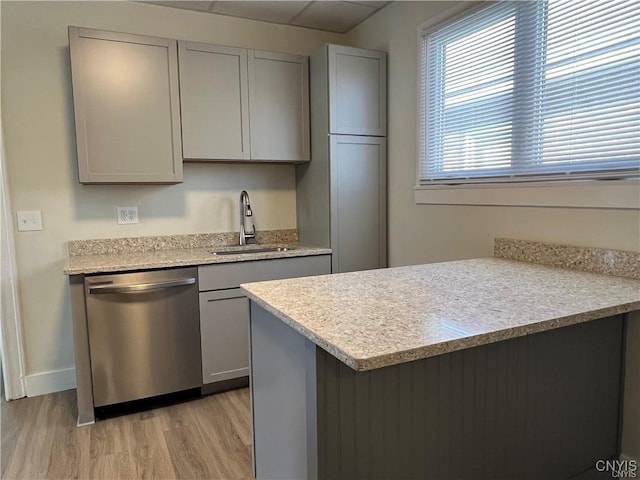 kitchen with stainless steel dishwasher, light hardwood / wood-style floors, gray cabinetry, and sink