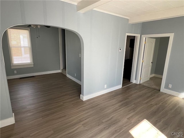 spare room with beam ceiling, crown molding, and dark hardwood / wood-style flooring