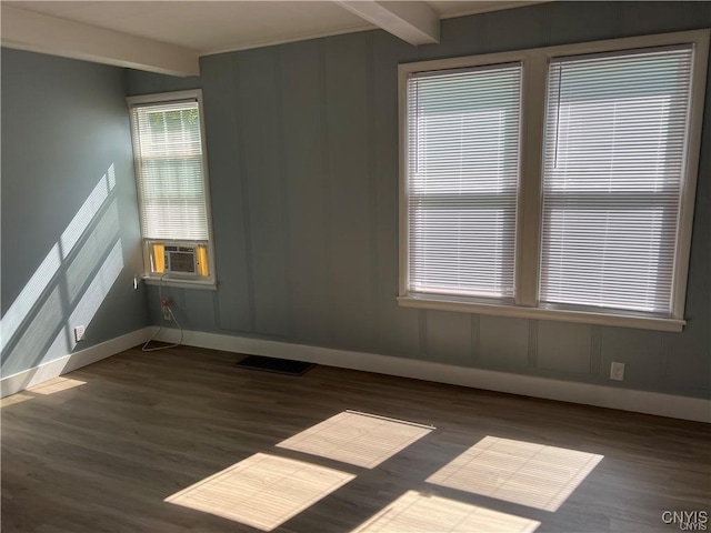 empty room featuring beam ceiling, dark hardwood / wood-style flooring, and cooling unit