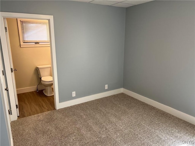 interior space with toilet and a drop ceiling