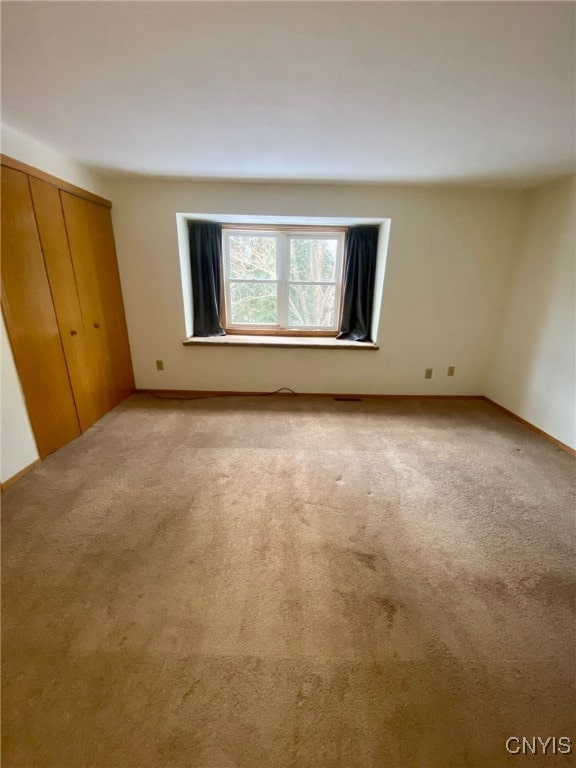 unfurnished bedroom featuring light carpet