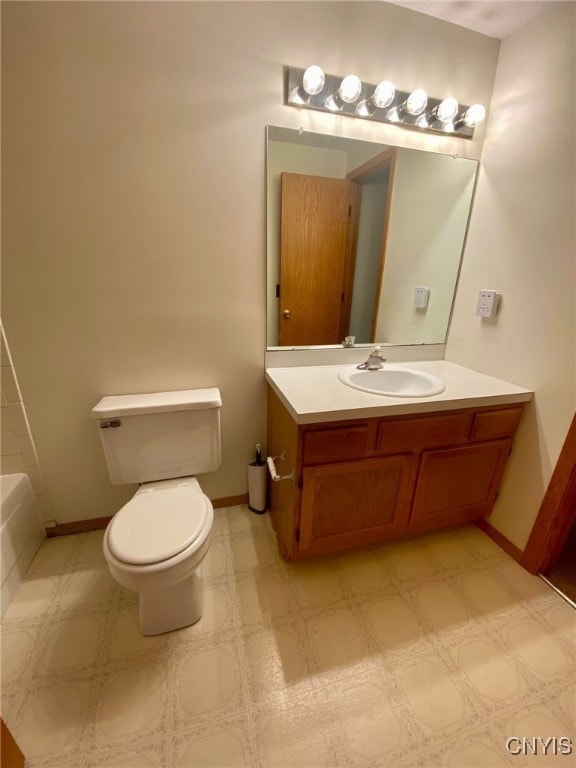 bathroom featuring a tub, vanity, and toilet