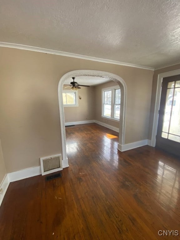 unfurnished room featuring crown molding, ceiling fan, dark hardwood / wood-style flooring, and a textured ceiling