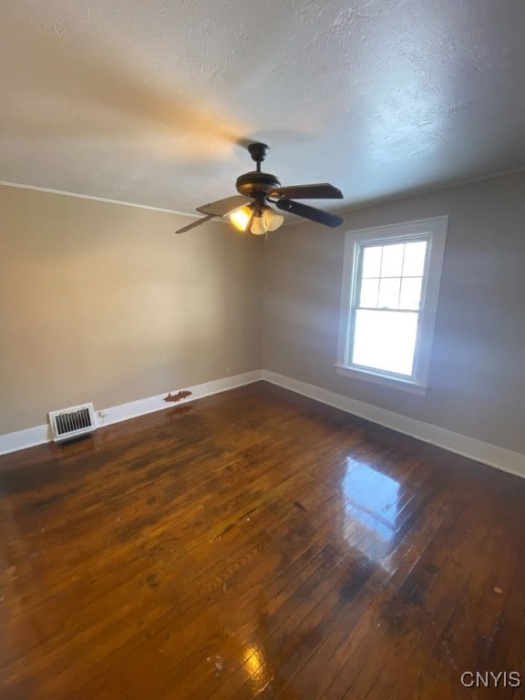 unfurnished room featuring dark hardwood / wood-style floors, ceiling fan, and a textured ceiling