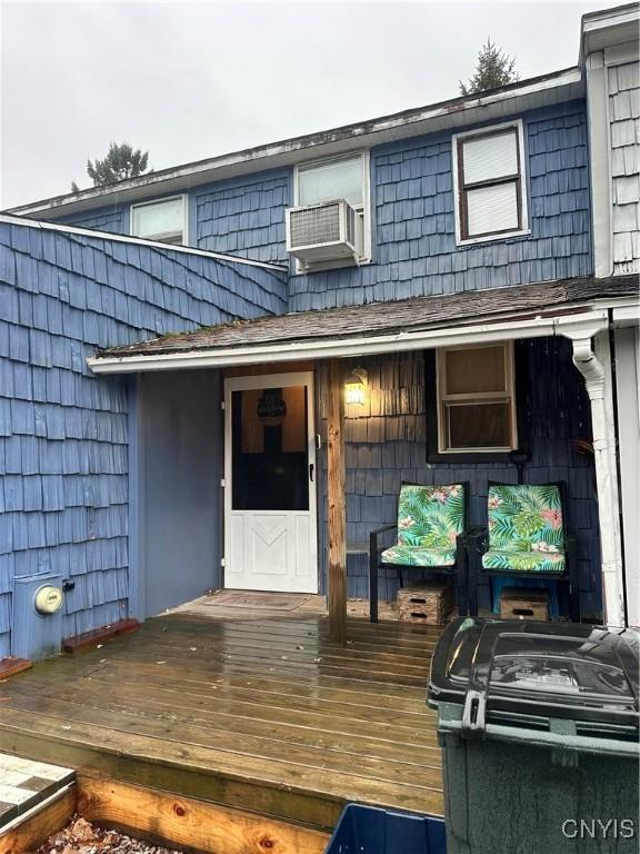 entrance to property featuring cooling unit and a wooden deck