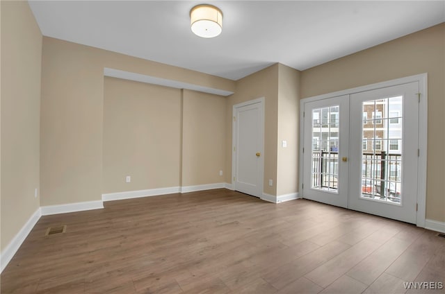 unfurnished room featuring hardwood / wood-style flooring and french doors