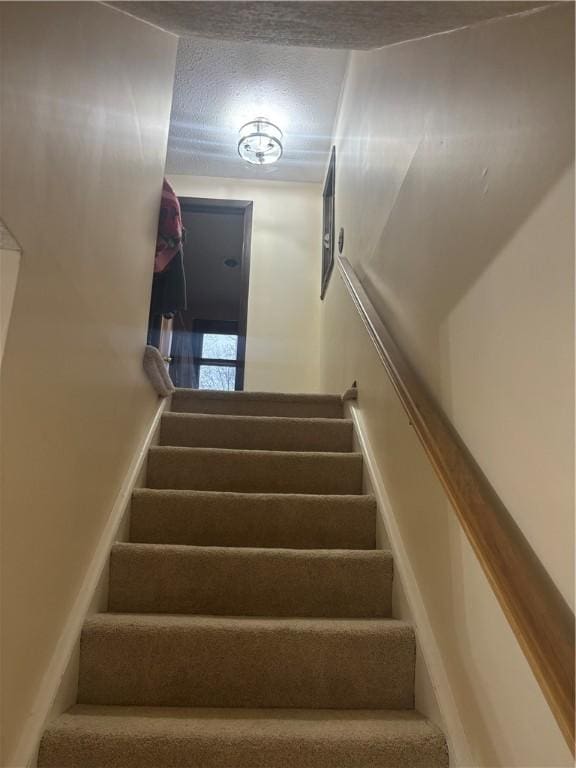 stairs with a textured ceiling