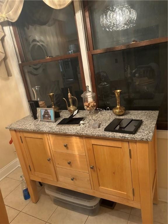 bar with light stone counters and light tile patterned floors