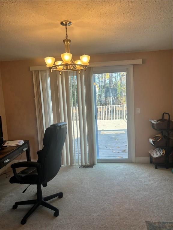 office space featuring carpet floors, a textured ceiling, and an inviting chandelier