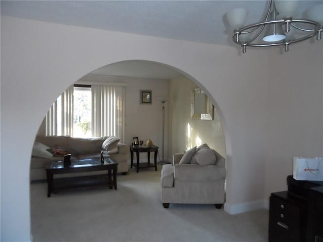 carpeted living room featuring a notable chandelier