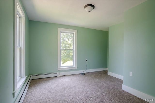 carpeted spare room featuring a baseboard heating unit