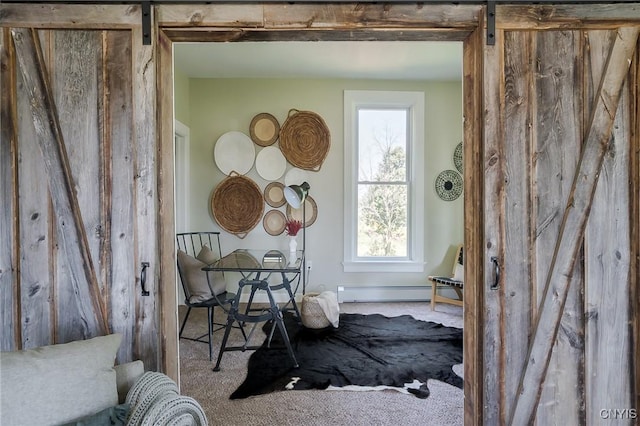 miscellaneous room with carpet flooring, a barn door, and baseboard heating