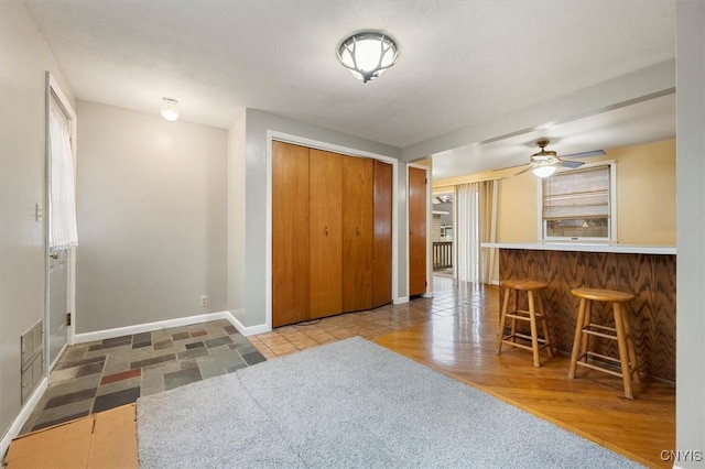 kitchen featuring a breakfast bar area, ceiling fan, and hardwood / wood-style floors