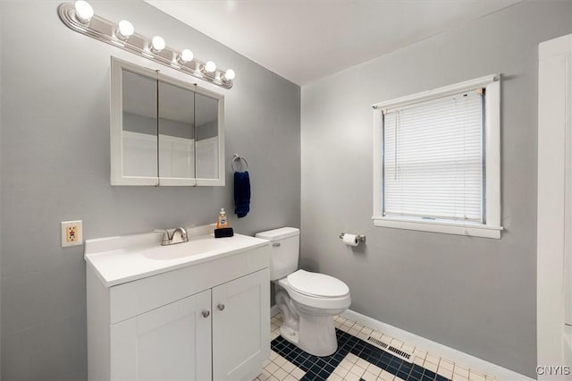 bathroom with tile patterned flooring, vanity, and toilet