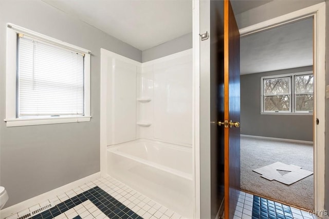 bathroom with toilet, tile patterned floors, and shower / bathtub combination