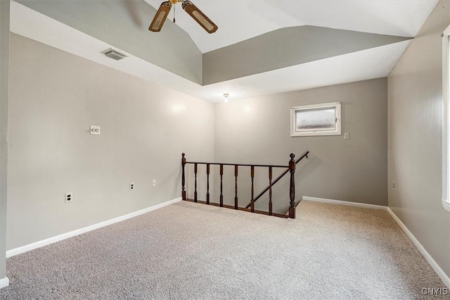 carpeted spare room featuring ceiling fan and vaulted ceiling