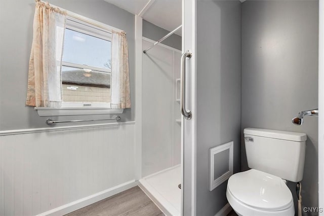 bathroom featuring toilet, wood-type flooring, and a shower