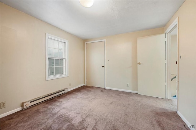 empty room featuring carpet and baseboard heating