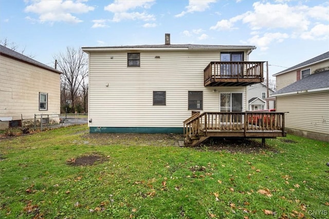 back of house featuring a lawn and a balcony