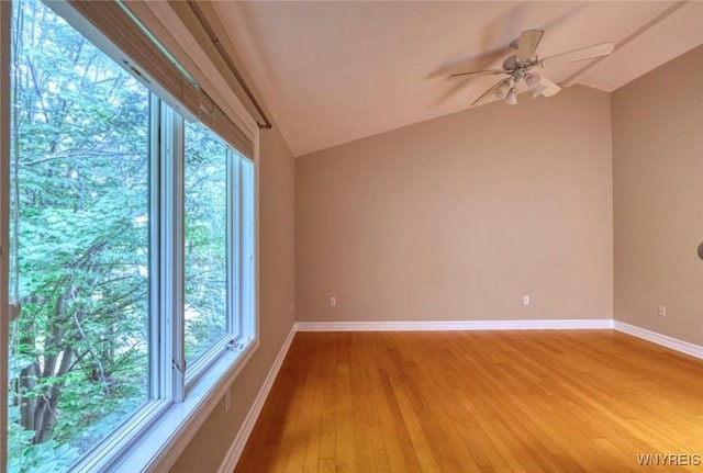 empty room with wood-type flooring, lofted ceiling, and ceiling fan